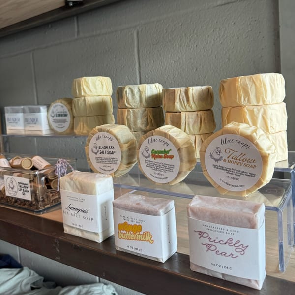 Artisan soaps in various scents like "Black Sea Salt" and "Prickly Pear" displayed on shelves.